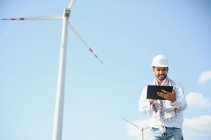 Indian Engineer working at alternative renewable wind energy farm - Sustainable energy industry